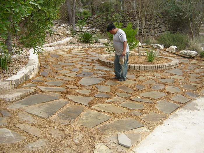 Plantings and beds soften the look of a water saving stepping stone themed xeriscape--San Marcos